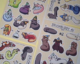 Puede incluir: Tres hojas de pegatinas etiquetadas como BRUSHBUDDY AU #1, #2, #3 y #4 con varias criaturas de dibujos animados con gorros de fiesta. Las coloridas ilustraciones muestran personajes pequeños y caprichosos en diferentes poses, algunos durmiendo, otros sonriendo y algunos con texto como hehe.
