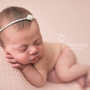 Dainty rhinestone headband for newborn photography, baptism, christening, or special occasion.  Small band of clear rhinestones with a silver finish and a simple silver pearl rhinestone embellishment.  Simply stunning baby headband.