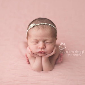 Dainty rhinestone headband for newborn photography, baptism, christening, or special occasion.  Small band of clear rhinestones with a silver finish and a simple silver pearl rhinestone embellishment.  Simply stunning baby headband.