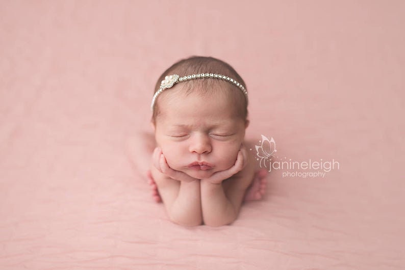 Dainty rhinestone headband for newborn photography, baptism, christening, or special occasion.  Small band of clear rhinestones with a silver finish and a simple silver pearl rhinestone embellishment.  Simply stunning baby headband.