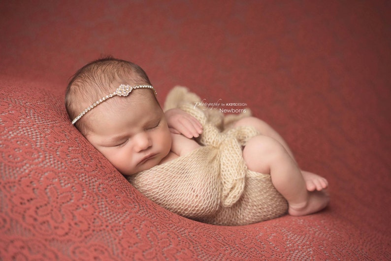 Dainty rhinestone headband for newborn photography, baptism, christening, or special occasion.  Small band of clear rhinestones with a gold finish and a simple gold rhinestone embellishment.  Simply stunning baby headband.