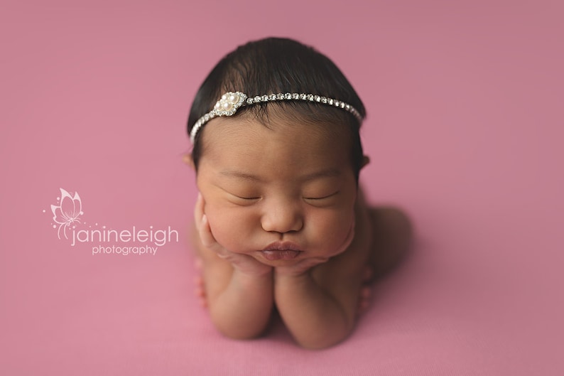 Dainty rhinestone headband for newborn photography, baptism, christening, or special occasion.  Small band of clear rhinestones with a silver finish and a simple silver pearl rhinestone embellishment.  Simply stunning baby headband.