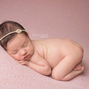 Dainty rhinestone headband for newborn photography, baptism, christening, or special occasion.  Small band of clear rhinestones with a gold finish and a simple gold rhinestone embellishment.  Simply stunning baby headband.