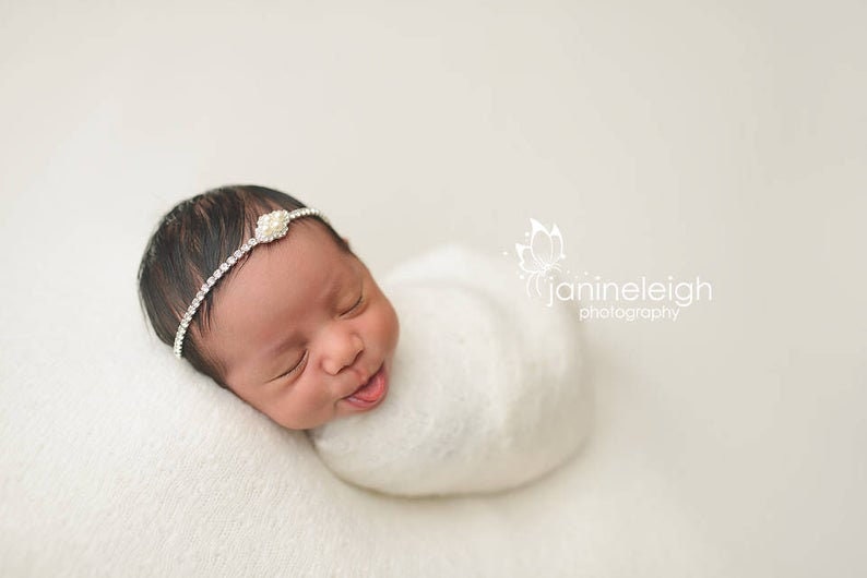 Dainty rhinestone headband for newborn photography, baptism, christening, or special occasion.  Small band of clear rhinestones with a silver finish and a simple silver pearl rhinestone embellishment.  Simply stunning baby headband.