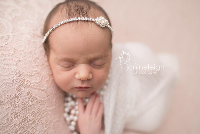 Dainty rhinestone headband for newborn photography, baptism, christening, or special occasion.  Small band of clear rhinestones with a silver finish and a simple silver pearl rhinestone embellishment.  Simply stunning baby headband.