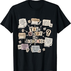 Op de afbeelding: Een zwart t-shirt met een grafisch ontwerp met de tekst "This shirt is decodable." Het ontwerp bevat diverse educatieve notities over fonetiek, zoals "Closed Syllable", "r-controlled", "Digraphs" en "S says /z/", gerangschikt in een collage.