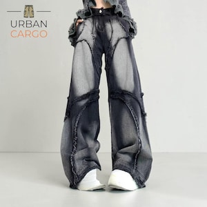 Könnte beinhalten: Dunkelblaue Jeans mit einzigartigem Design. Die Jeans haben ein weites Bein und einen verwaschenen, abgenutzten Look. Der Text "URBAN CARGO" ist oben links sichtbar.