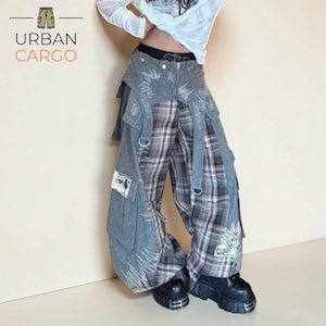 May include: Denim cargo trousers with a grey and white plaid pattern. The trousers feature multiple pockets, straps, and decorative stitching. The brand logo "URBAN CARGO" is visible in the upper left corner.