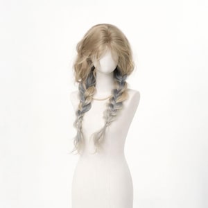 May include: A blonde wig with wavy hair and two long, braided pigtails. The braids are a mix of blonde and light blue. The wig is displayed on a mannequin with a white background.