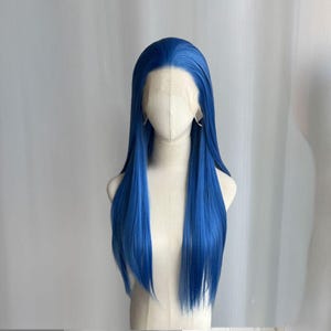 Peut inclure: Perruque bleue, longue et raide, avec un devant en dentelle, présentée sur une tête de mannequin. La perruque a une ligne de cheveux d'apparence naturelle et est coiffée avec une raie au milieu. La couleur bleu vif est uniforme sur les longues mèches.