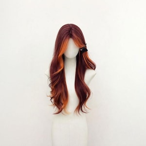 Peut inclure: Perruque longue et ondulée, mélangeant des tons bordeaux et orange. Elle est coiffée avec une raie sur le côté et une pince à cheveux noire. Les cheveux sont en couches et ont une texture naturelle, idéale pour le cosplay ou le quotidien.