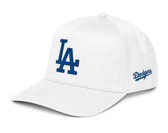 Può includere: Cappellino da baseball bianco con il logo blu "LA" sul davanti e la scritta "Dodgers" in blu sul lato. Il cappellino ha una visiera curva e una vestibilità strutturata, adatta per lo sport o l'abbigliamento casual.