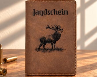 May include: A brown leather document holder featuring the word Jagdschein and an illustration of a stag. The cover has visible stitching along the edges. Several brass-colored metal shell casings are positioned to the left of the holder.