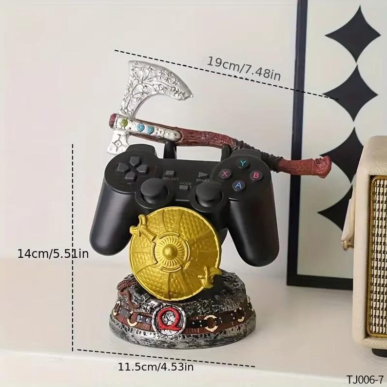 K&ouml;nnte beinhalten: Ein schwarzer Videospiel-Controller mit einer dekorativen Axt und einem Schild. Die Axt ist silber und braun, und der Schild ist goldfarben. Der Sockel ist ein detailliertes, mehrfarbiges Design. Der Controller ist 14 cm hoch und die Axt 19 cm lang.