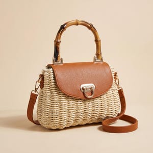 Puede incluir: Bolso de mano de paja tejida con asa de bambú y solapa de cuero marrón. El bolso tiene una correa de hombro marrón desmontable y un cierre plateado. El bolso es de color beige claro.