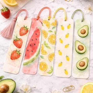 May include: A collection of watercolor bookmarks featuring fruit designs. The bookmarks showcase strawberries, watermelon, lemons, and avocados. Each bookmark has a colorful design and a coordinating tassel or loop. The background is a marble surface.