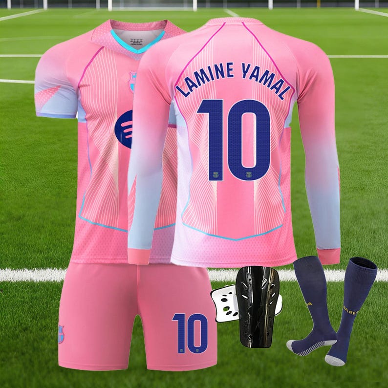 May include: A pink soccer uniform set with a jersey, shorts, and socks. The jersey has the name "LAMINE YAMAL" and the number "10" on the back. The shorts also feature the number "10". Includes shin guards.