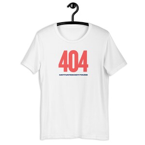 Könnte beinhalten: Weißes T-Shirt mit der Zahl "404" in Koralle und dem Text "MOTIVATION NOT FOUND" in Marineblau. Das T-Shirt hängt an einem schwarzen Kleiderbügel.