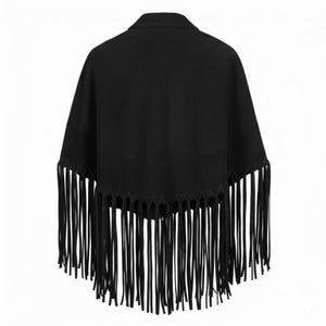 May include: A solid black poncho featuring a structured collar and a V-shaped hemline. The garment is adorned with long, thin black fringe detailing that hangs from the lower edge, creating a layered and textured appearance across the entire piece.