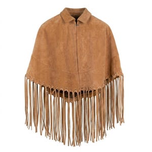 May include: A tan suede poncho featuring a classic collar, a single metal hook-and-eye closure at the neckline, and a wide horizontal seam across the chest. The bottom hem is finished with long, thin, matching suede fringe detailing.