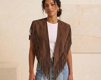 May include: A dark brown suede vest featuring a deep V-neckline and long, flowing fringe detailing along the front edges. The garment is sleeveless, open-front, and constructed from a soft, matte-textured material that drapes over the shoulders.