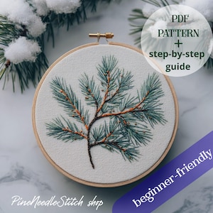 Puede incluir: Un bastidor de bordado con un diseño detallado de agujas de pino. El diseño está bordado en tonos verdes y marrones sobre tela blanca. El texto en la imagen dice "PDF PATTERN + step-by-step guide" y "beginner-friendly". También se ve el nombre de la tienda "Pine Needle Stitch shop".