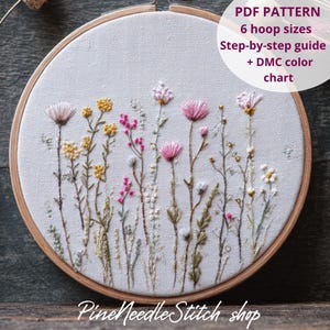 May include: Embroidered floral design in a wooden hoop. The artwork features pink, yellow, and white flowers with green stems on a white fabric. Text on the image reads "PDF PATTERN" and "Pine Needle Stitch shop".