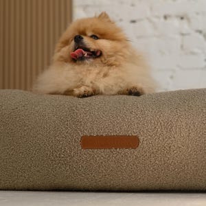 May include: A set of three ceramic mugs with a speckled, matte finish. The mugs are in shades of cream, light brown, and dark brown. Each mug has a simple, minimalist design, perfect for coffee or tea.