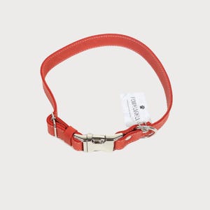 Puede incluir: Un collar rojo de cuero para perros con costuras blancas y una hebilla de metal plateado. Una etiqueta blanca con el texto "PAW AREA" est&aacute; adjunta al collar.