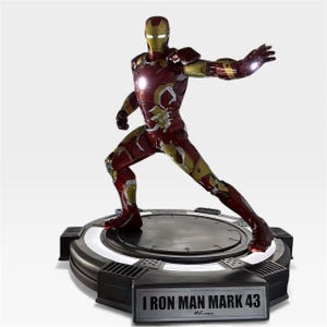 May include: A detailed figurine of Iron Man Mark 43 in a dynamic pose, featuring a red and gold armored suit. The figure stands on a black circular base with a glowing white ring and the text "IRON MAN MARK 43".
