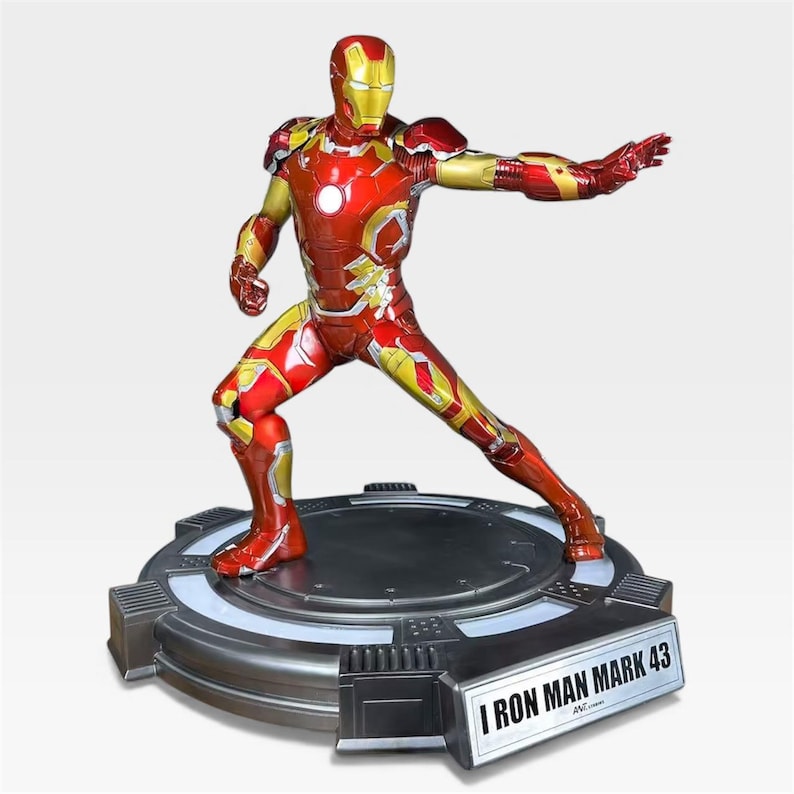May include: A detailed Iron Man Mark 43 figurine in a dynamic pose, predominantly red and gold. The figure stands on a metallic base with the text "I IRON MAN MARK 43". The superhero's armor features intricate detailing and a glossy finish, capturing a sense of action.