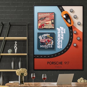 Puede incluir: Una impresión artística enmarcada con un tema de coches antiguos. La obra de arte incluye dos imágenes enmarcadas más pequeñas con ilustraciones de coches clásicos y texto. Un coche de juguete naranja está posicionado sobre un gráfico de carretera, con el texto "THE FATE OF THE FURIOUS" y "PORSCHE 917 1969".