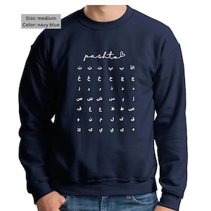 May include: Navy blue sweatshirt with white Pashto script and alphabet chart. The word "pashtob" is written in a cursive font above the alphabet. The sweatshirt is medium size.