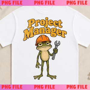 May include: A white t-shirt featuring a graphic of a green frog wearing an orange hard hat and holding a silver wrench. Above the frog, the text Project Manager is printed in a bold, yellow, retro-style font with a dark outline.