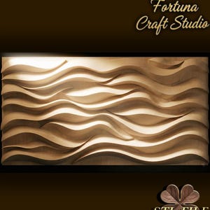 May include: A wooden wall art piece with a wave-like design. The artwork is framed in black and features a series of flowing, curved lines that create a sense of depth and movement. The text "Design by Fortuna Craft Studio" is visible.