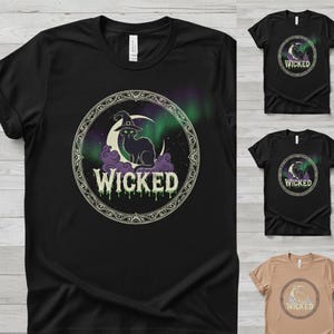 Könnte beinhalten: Schwarzes T-Shirt mit einem kreisförmigen Design, das eine schwarze Katze mit Hexenhut, einen Mond und das Wort "WICKED" in tropfendem Grün zeigt. Das Design ist von einem verzierten Rahmen umgeben, mit zusätzlichen Shirts im Bild.