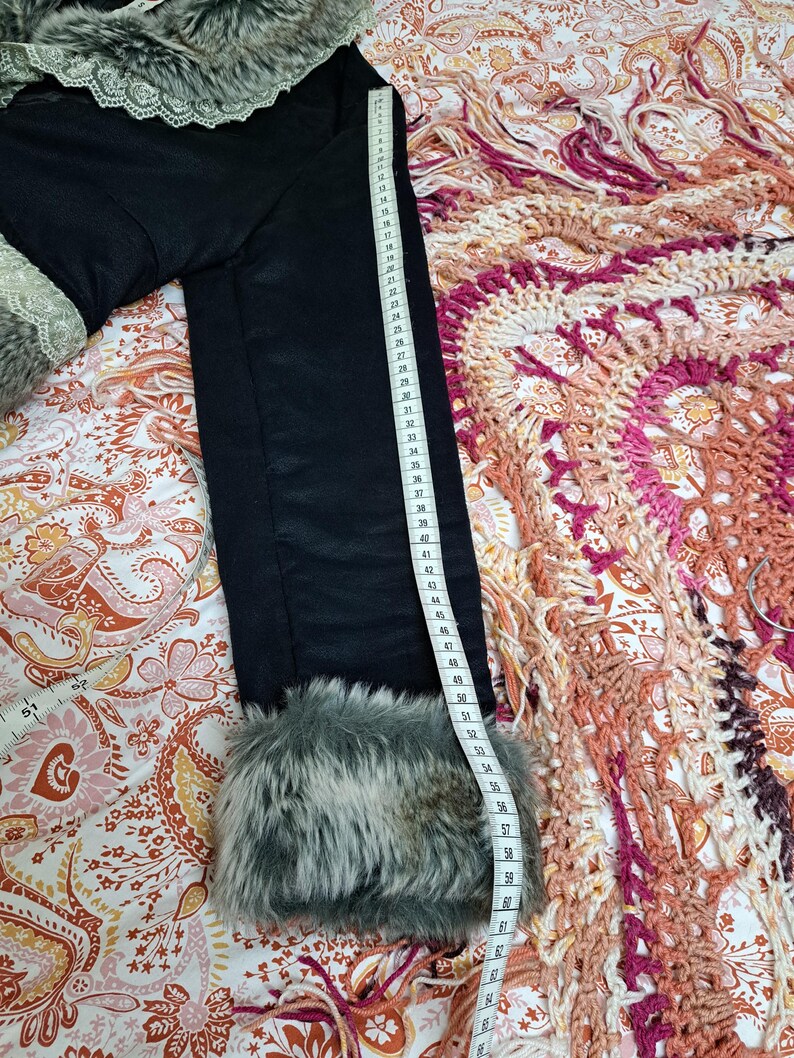 K&ouml;nnte beinhalten: Schwarze Jacke mit Kunstfellbesatz an den Manschetten und am Kragen. Die Jacke wird mit einem Ma&szlig;band gemessen. Die L&auml;nge der Jacke betr&auml;gt ca. 147 cm.