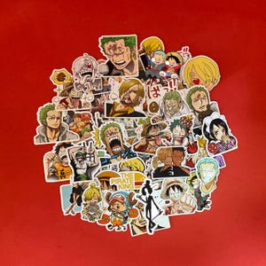 May include: A collection of colorful stickers featuring various anime characters on a red background. The stickers showcase different characters with diverse expressions and poses, including text that reads "THE PIRATE KING".