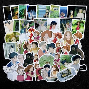 Pu&ograve; includere: Una collezione di adesivi in stile anime con vari personaggi e scene. Gli adesivi presentano una variet&agrave; di colori e design, con illustrazioni dettagliate. Gli adesivi sono disposti su una superficie nera.