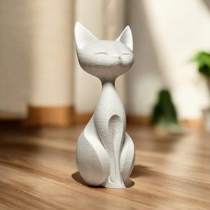 Peut inclure: Une figurine de chat blanche au design minimaliste. Le chat est assis droit, les yeux fermés, et son corps présente des lignes lisses et courbes. La figurine est en matériau mat et repose sur une surface en bois.
