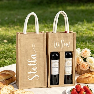 Può includere: Due borse rettangolari per vino in juta color marrone chiaro con manici in corda bianca. Una borsa presenta il nome Stella in corsivo bianco, mentre l'altra presenta il nome Willow e contiene due bottiglie di vino Bordeaux con etichette.