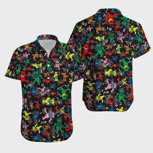 May include: Black short-sleeved button-down shirt with a colorful pattern of dancing bears, musical notes, and hearts. The bears are in various colors, including red, yellow, green, and blue. The shirt has a classic collar and a relaxed fit.
