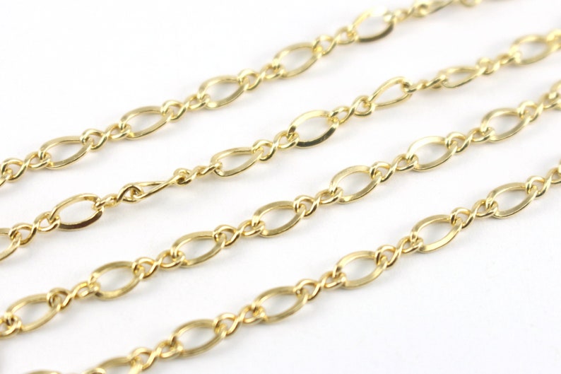 May include: Gold chain with a delicate, oval-shaped link design. The chain is made of metal and has a shiny finish.