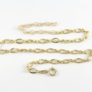 May include: A gold chain necklace with a lobster clasp closure. The chain is made of oval links.