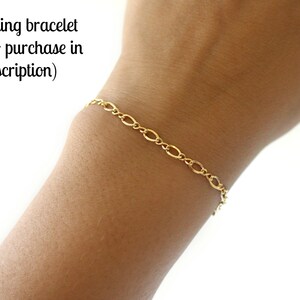 May include: A gold chain bracelet on a person's wrist.  matching bracelet (link to purchase in description)