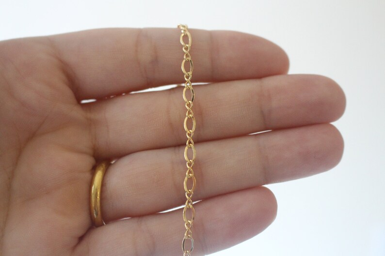 May include: A gold chain necklace with a delicate oval link design.