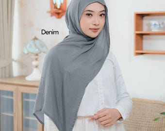 May include: A woman wearing a denim-colored hijab and a white dress. The hijab is draped over the head and shoulders. The word "Denim" is printed on the image.