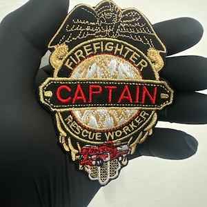 Può includere: Toppa da capitano dei vigili del fuoco ricamata con dettagli oro, rossi e bianchi. La toppa presenta le parole "Firefighter Captain Rescue Worker" e una grafica di un'autopompa.
