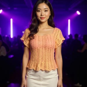 May include: A peach-colored, short-sleeved crochet top with a square neckline and a flared hem. The top is paired with a white denim skirt. The background is a blurred purple with lights.