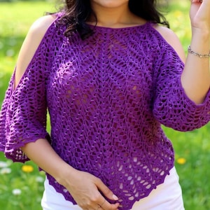 Puede incluir: Un top de ganchillo morado vibrante con mangas con hombros descubiertos. El top presenta un patrón de tejido abierto detallado en todo el cuerpo y las mangas. La prenda es de color liso y parece hecha a mano.